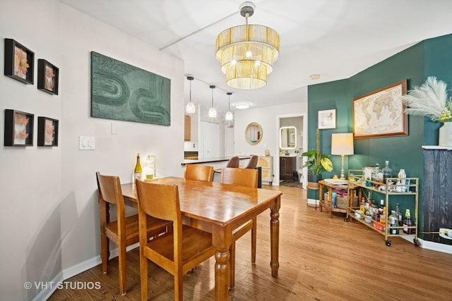 222 E Pearson St Unit 409, Chicago, IL 60611 - dining space featuring baseboards, a notable chandelier, and wood finished floors