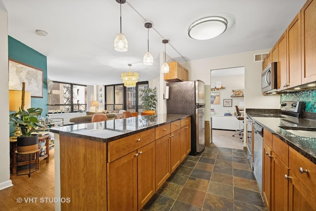 222 E Pearson St Unit 409, Chicago, IL 60611 - kitchen with stainless steel appliances, a peninsula, open floor plan, visible vents, and brown cabinets