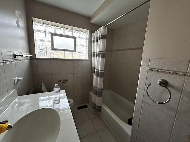 full bathroom with tile patterned floors, toilet, vanity, tile walls, and shower / bath combo
