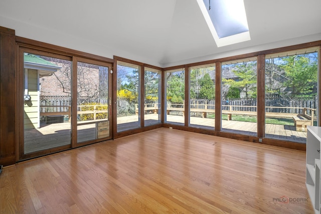 unfurnished sunroom with a skylight, a wooden deck, and wood finished floors