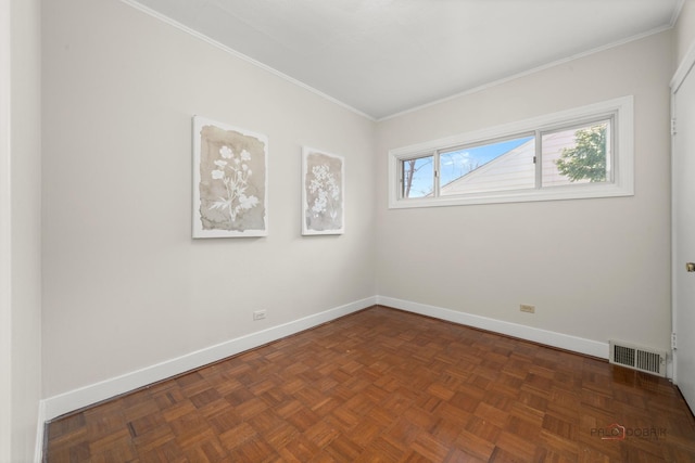 spare room with crown molding, baseboards, and visible vents
