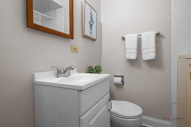 bathroom featuring vanity, baseboards, and toilet