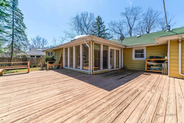 wooden terrace with a sunroom and fence