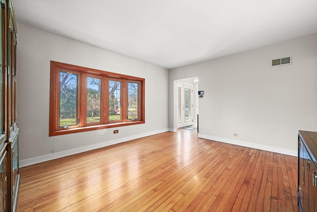 interior space with light wood-style flooring, baseboards, and visible vents