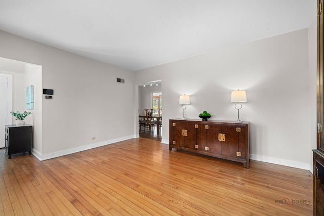 sitting room with baseboards, wood-type flooring, and visible vents