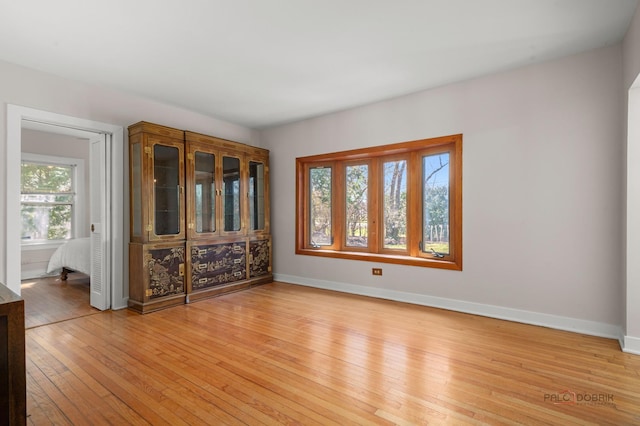 empty room featuring light wood-type flooring and baseboards