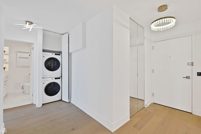 1560 N Sandburg Ter Unit 1011J, Chicago, IL 60610 - laundry area with baseboards, light wood-style flooring, stacked washer / dryer, laundry area, and ceiling fan