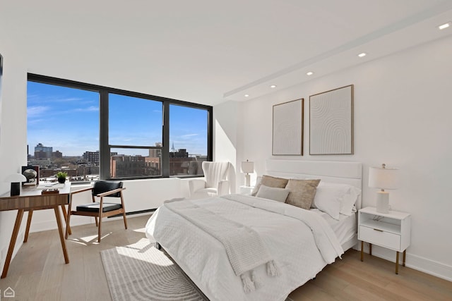 1560 N Sandburg Ter Unit 1011J, Chicago, IL 60610 - bedroom with recessed lighting, a city view, light wood-style flooring, and baseboards