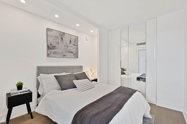 1560 N Sandburg Ter Unit 1011J, Chicago, IL 60610 - bedroom featuring light wood-style floors, a closet, baseboards, and recessed lighting