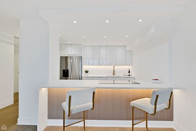 1560 N Sandburg Ter Unit 1011J, Chicago, IL 60610 - kitchen featuring a kitchen breakfast bar, stainless steel fridge, a peninsula, and modern cabinets