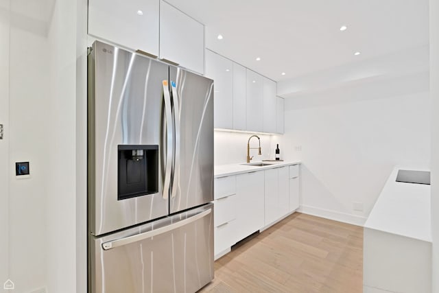 1560 N Sandburg Ter Unit 1011J, Chicago, IL 60610 - kitchen featuring stainless steel fridge with ice dispenser, white cabinets, modern cabinets, light wood finished floors, and a sink