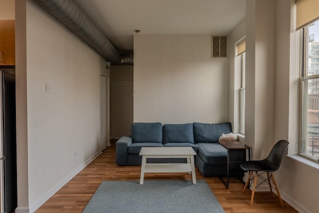 living area with visible vents, baseboards, and light wood-style flooring