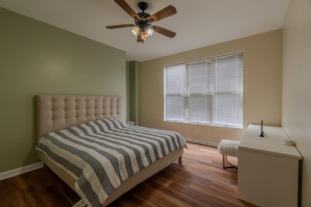 bedroom featuring ceiling fan, baseboards, and wood finished floors