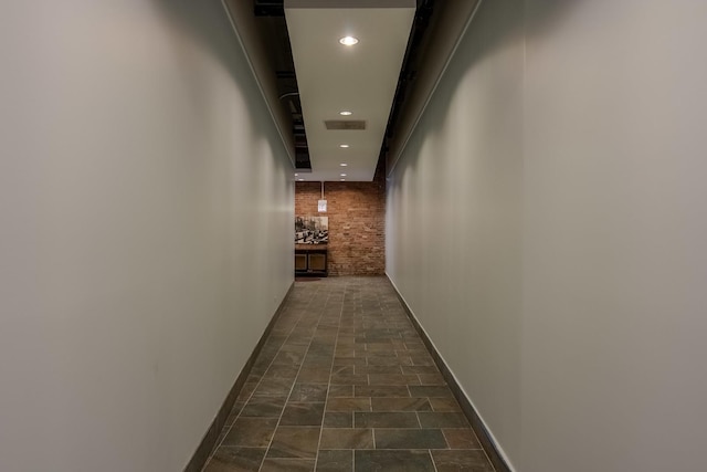 corridor with recessed lighting, stone finish floor, visible vents, and baseboards