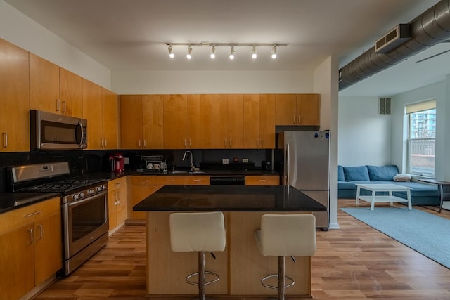 kitchen featuring a sink, visible vents, light wood finished floors, and stainless steel appliances
