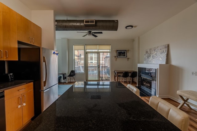 living room featuring a fireplace, visible vents, and a ceiling fan