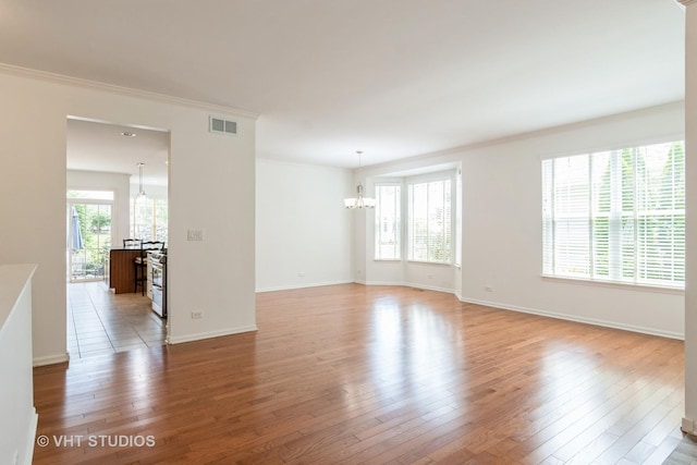 1177 Heathrow Ln, Aurora, IL 60502 - empty room with a chandelier, light wood-style floors, and crown molding