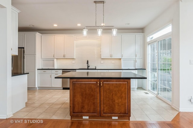1177 Heathrow Ln, Aurora, IL 60502 - kitchen featuring stainless steel appliances, dark countertops, a center island, backsplash, and recessed lighting