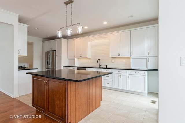 1177 Heathrow Ln, Aurora, IL 60502 - kitchen featuring stainless steel refrigerator with ice dispenser, dark countertops, white cabinetry, a kitchen island, and recessed lighting