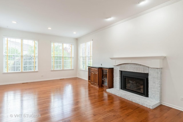 1177 Heathrow Ln, Aurora, IL 60502 - unfurnished living room featuring a fireplace, wood finished floors, crown molding, and recessed lighting