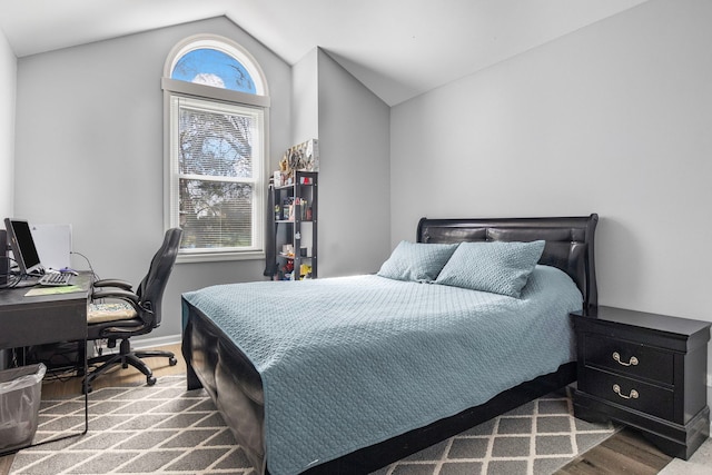 bedroom featuring wood finished floors, baseboards, and vaulted ceiling