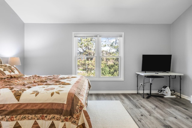 bedroom with baseboards and wood finished floors
