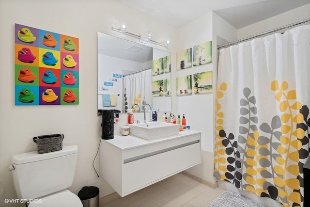 bathroom featuring vanity, curtained shower, and toilet