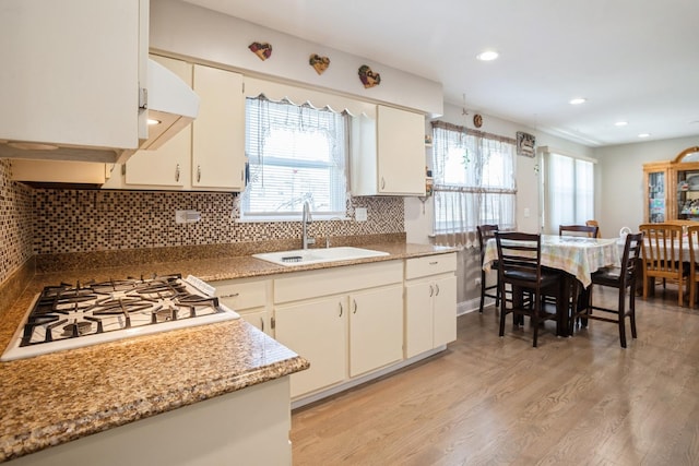 kitchen featuring light wood-type flooring, recessed lighting, a sink, white gas stovetop, and backsplash