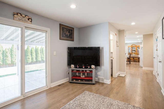 living area featuring light wood-type flooring, baseboards, visible vents, and recessed lighting