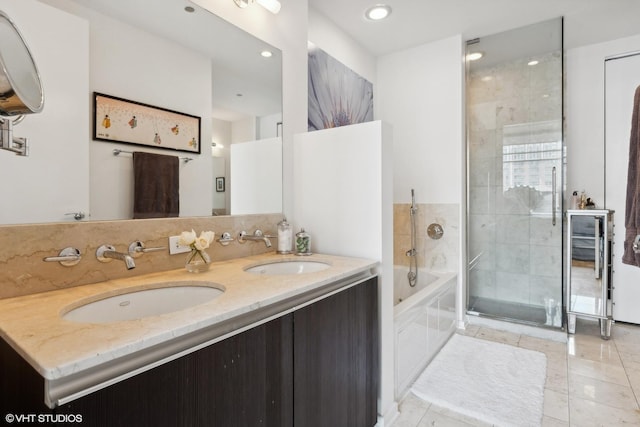 bathroom featuring a bath, tiled shower, double vanity, and a sink