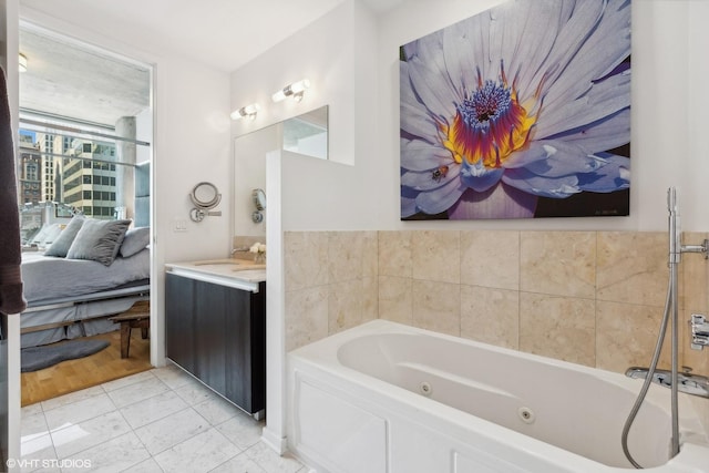 ensuite bathroom with vanity, a jetted tub, and ensuite bathroom