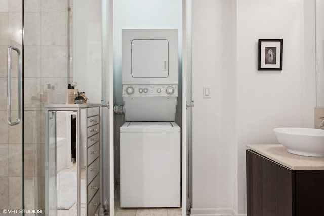 laundry room with a sink and stacked washer and clothes dryer
