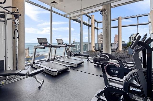 workout area with visible vents, a wall of windows, and a wealth of natural light