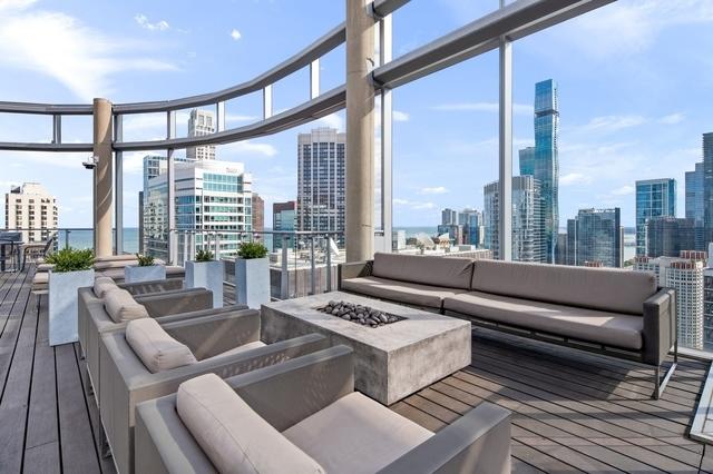 wooden deck with an outdoor living space with a fire pit and a city view