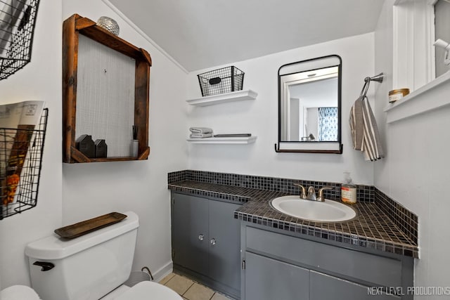 bathroom featuring toilet, vanity, and tile patterned floors