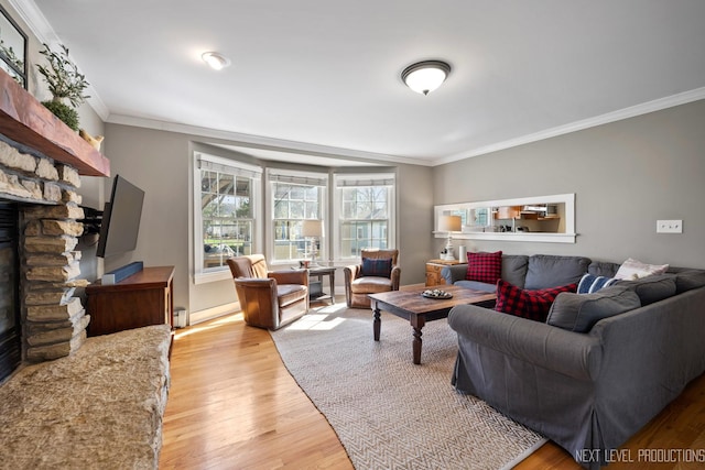 living area featuring a baseboard heating unit, a fireplace, light wood-style floors, and ornamental molding