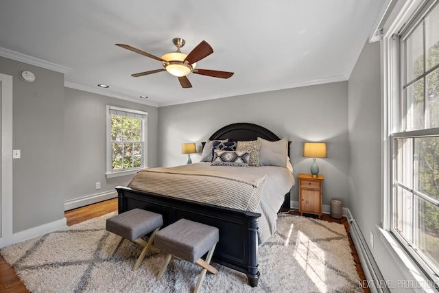 bedroom featuring a baseboard heating unit, a baseboard radiator, baseboards, and wood finished floors