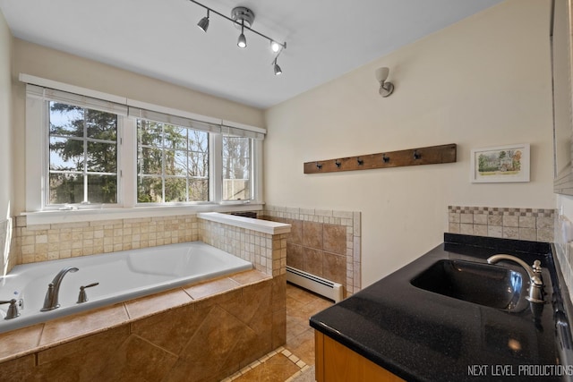 bathroom with a baseboard radiator, a garden tub, tile patterned flooring, and a sink