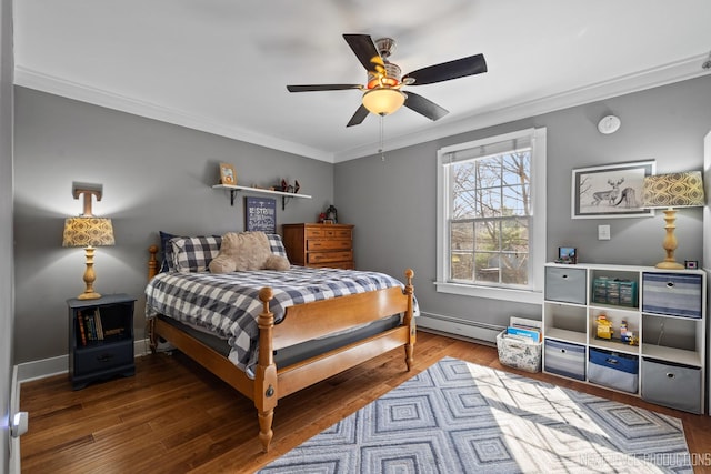 bedroom featuring baseboard heating, wood finished floors, ornamental molding, and a ceiling fan