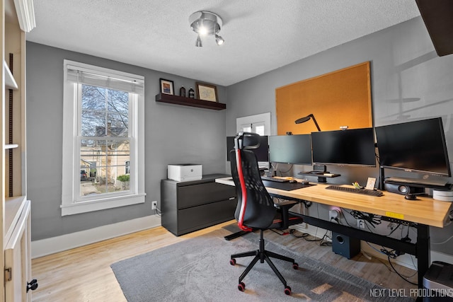 office space featuring baseboards, wood finished floors, and a textured ceiling