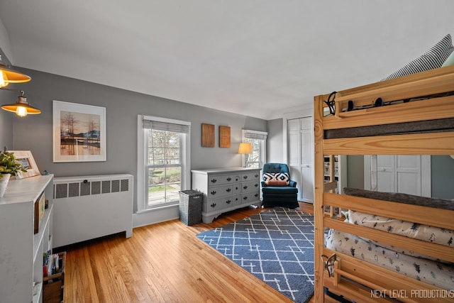 bedroom with radiator and wood finished floors