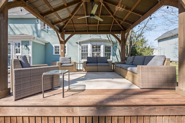wooden deck with an outdoor living space, ceiling fan, and a gazebo