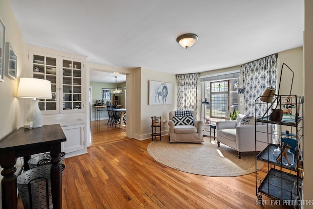 sitting room with baseboards and hardwood / wood-style flooring