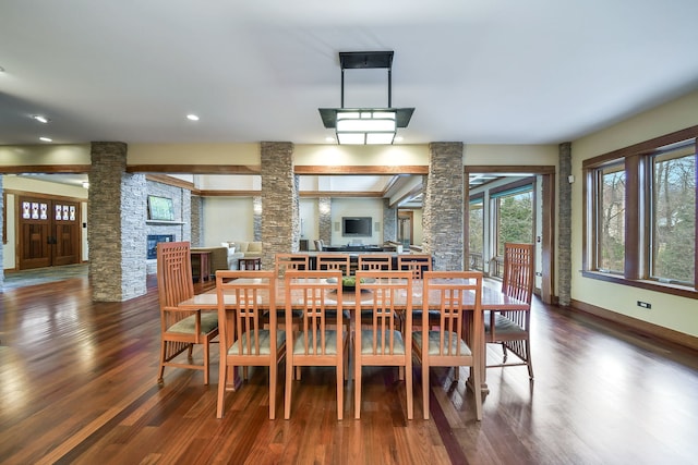 dining area with decorative columns, a fireplace, wood finished floors, recessed lighting, and baseboards