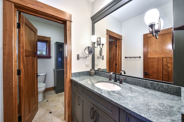bathroom with toilet, vanity, and tile patterned floors