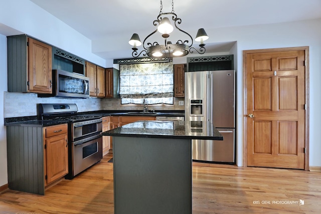 536 Circle Dr, Fox Lake, IL 60020 - kitchen with appliances with stainless steel finishes, tasteful backsplash, a center island, light wood-type flooring, and a chandelier
