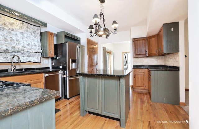 536 Circle Dr, Fox Lake, IL 60020 - kitchen featuring stainless steel appliances, a chandelier, backsplash, light wood-type flooring, and decorative light fixtures