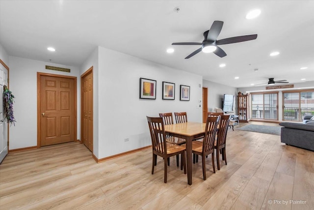 dining area featuring baseboards, a ceiling fan, and light wood finished floors