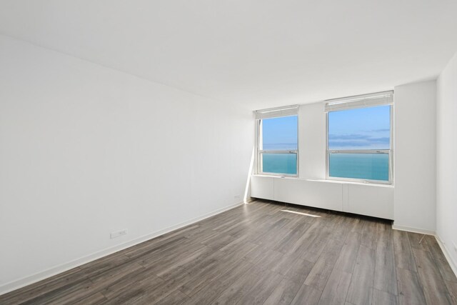 spare room with dark wood-style floors and baseboards
