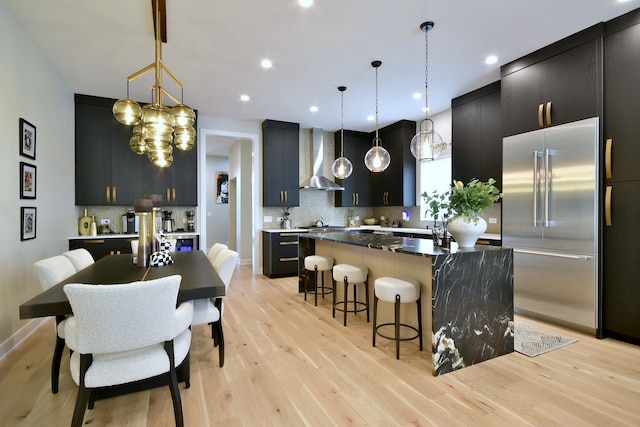 262 N Addison Ave, Elmhurst, IL 60126 - kitchen featuring high end refrigerator, wall chimney range hood, a kitchen island, a kitchen bar, and tasteful backsplash